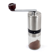 Kompakt kaffekvarn i metall med trähandtag och genomskinlig botten för visning av malt kaffe.
